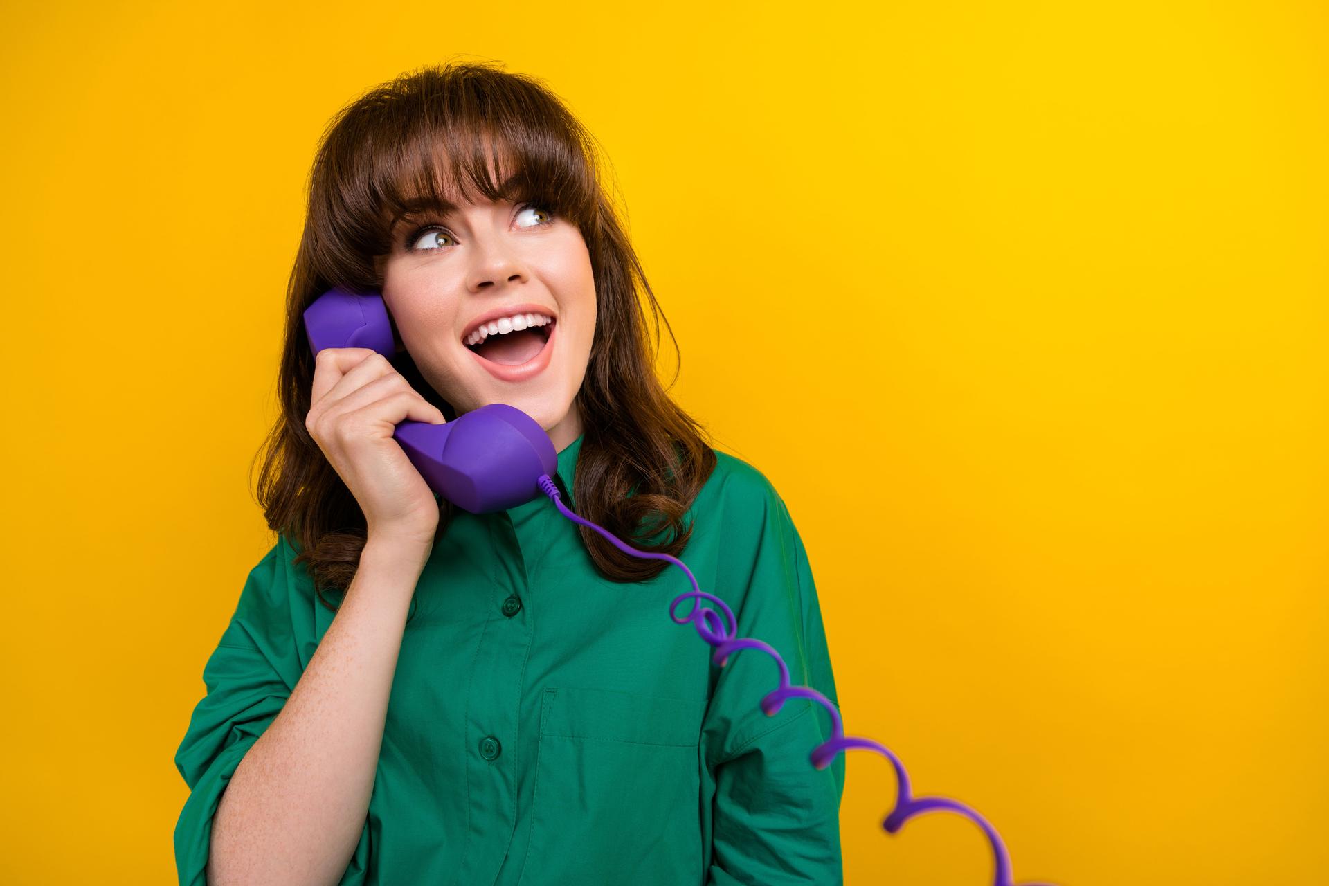 Photo of sweet dreamy lady wear green shirt communicating phone looking empty space isolated yellow color background